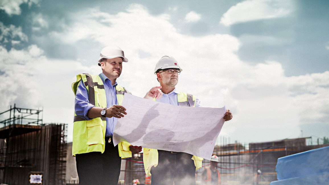 Ingenieure-Sicherheitsausrüstung-Schutzhelme-gelbe-Sicherheitswesen-Bauplan-Baustelle-Baugerüste