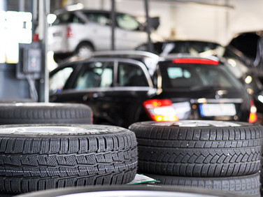 gestapelte-Reifen-Autowerkstatt-schwarze-Autos
